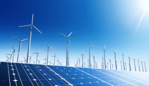 Wind and solar farm hybrid with panels in the foreground and windmills in the background